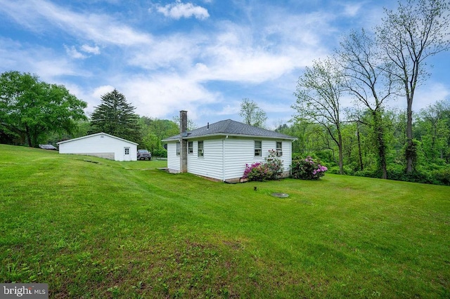 view of green lawn with a detached garage