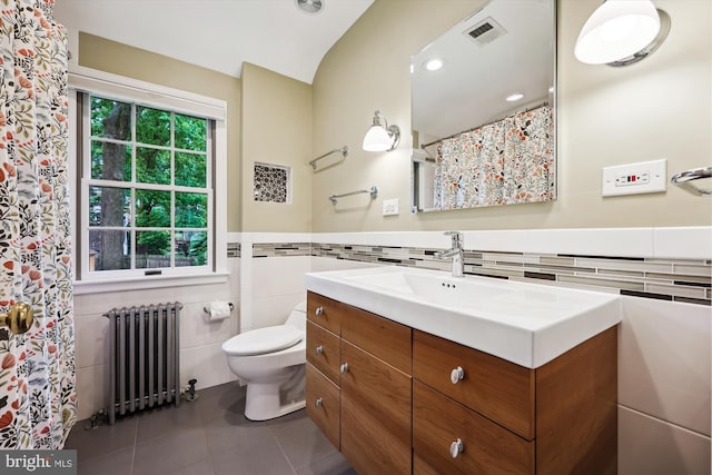 full bath with radiator, tile walls, tile patterned flooring, toilet, and vanity