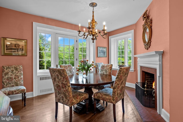 1182 Wrack Rd, Meadowbrook, PA 19046 - dining room featuring radiator, a chandelier, baseboards, a fireplace, and dark wood-style flooring