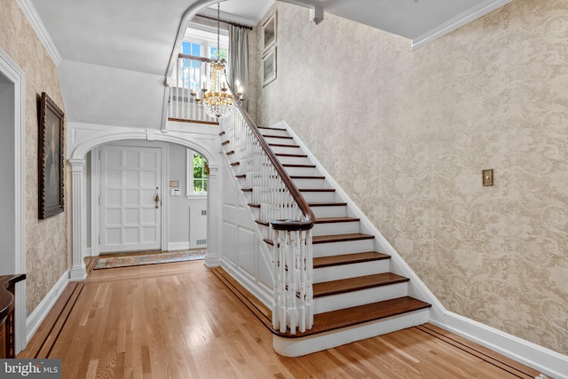1182 Wrack Rd, Meadowbrook, PA 19046 - entryway featuring wood finished floors, a chandelier, healthy amount of natural light, wallpapered walls, and arched walkways