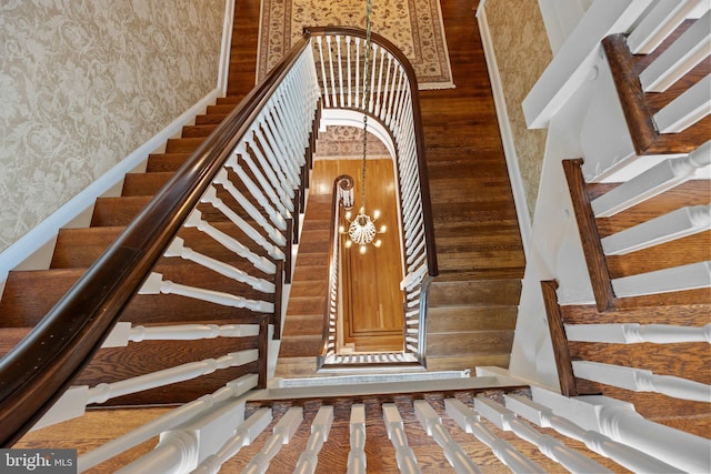 1182 Wrack Rd, Meadowbrook, PA 19046 - stairs featuring wallpapered walls, wooden walls, and a chandelier