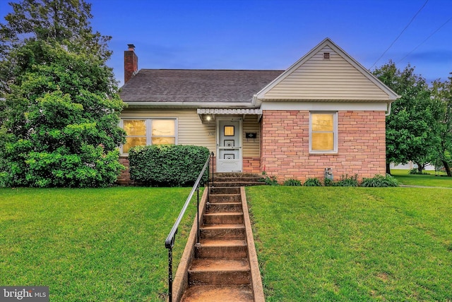 374 E Maple St, Dallastown, PA 17313 - view of front facade with a chimney, roof with shingles, and a front lawn