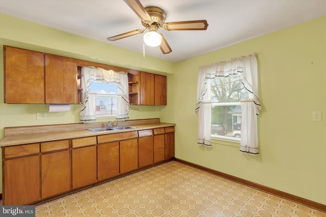374 E Maple St, Dallastown, PA 17313 - kitchen with a sink, brown cabinets, light countertops, baseboards, and a ceiling fan