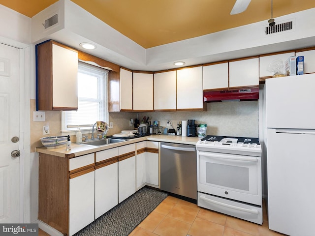 831 Windsor St, Wilmington, DE 19801 - kitchen with white appliances, under cabinet range hood, a sink, light countertops, and white cabinets
