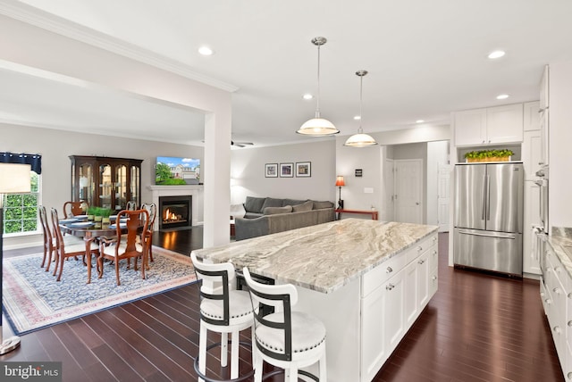 20355 Snowpoint Pl, Ashburn, VA 20147 - kitchen with stainless steel refrigerator, ornamental molding, dark wood-style flooring, light stone counters, and a kitchen island
