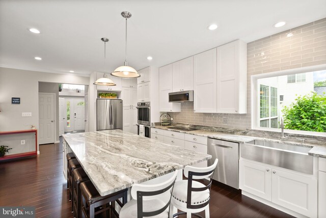 20355 Snowpoint Pl, Ashburn, VA 20147 - kitchen with appliances with stainless steel finishes, a sink, light stone countertops, white cabinets, and recessed lighting