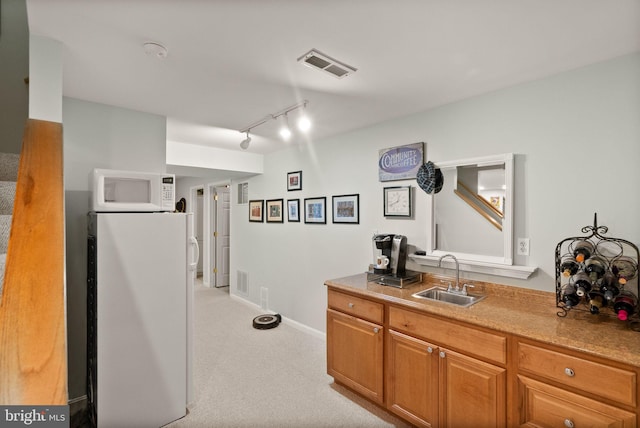 20355 Snowpoint Pl, Ashburn, VA 20147 - kitchen featuring a sink, white appliances, light colored carpet, track lighting, and baseboards