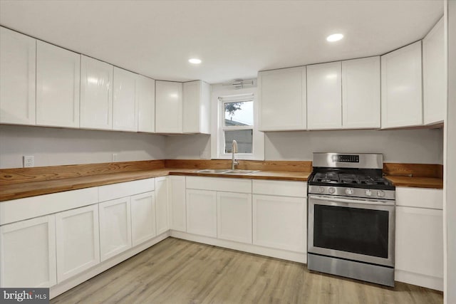 134 S Market St, New Cumberland, PA 17070 - kitchen with stainless steel gas range oven, a sink, wood counters, white cabinets, and light wood-style flooring