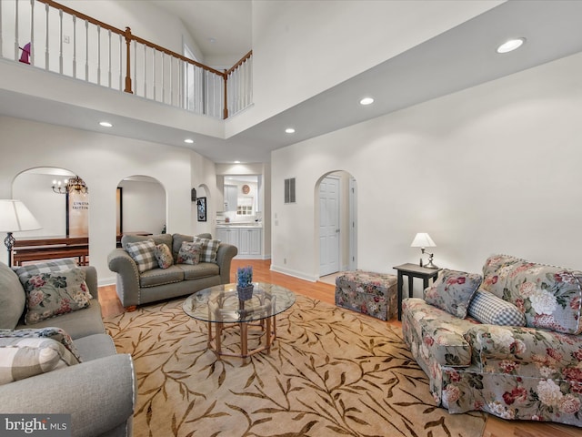 37 Sussex St, Rehoboth Beach, DE 19971 - living area with arched walkways, wood finished floors, recessed lighting, a towering ceiling, and baseboards