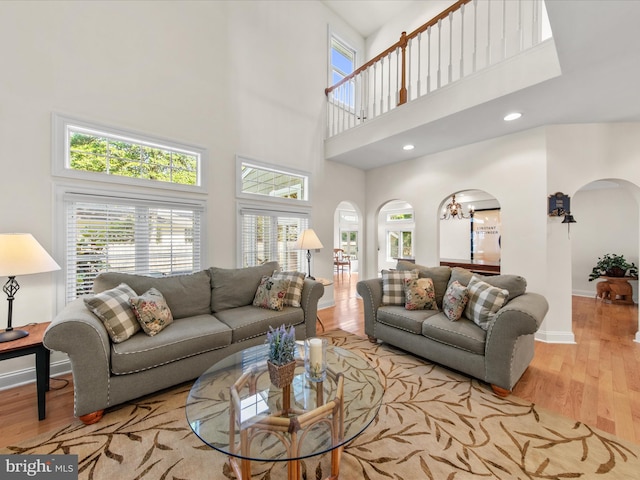 37 Sussex St, Rehoboth Beach, DE 19971 - living area with arched walkways, a towering ceiling, wood finished floors, baseboards, and recessed lighting