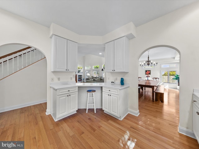 37 Sussex St, Rehoboth Beach, DE 19971 - bar area featuring arched walkways, light wood-style floors, a chandelier, and stairs