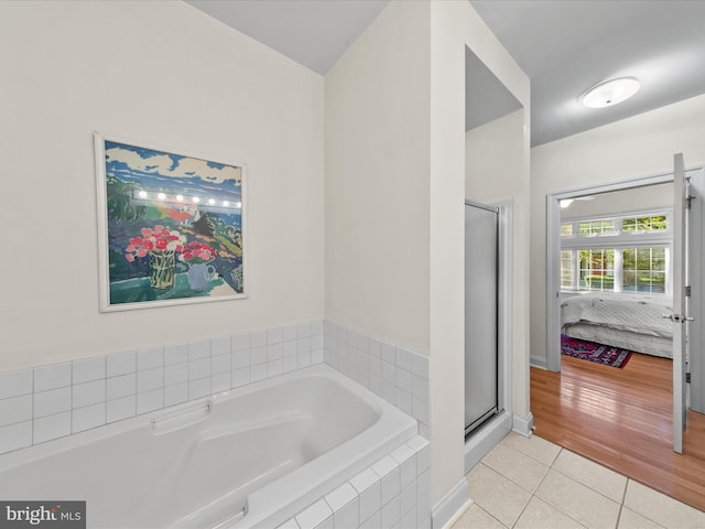37 Sussex St, Rehoboth Beach, DE 19971 - bathroom with tile patterned flooring, connected bathroom, a stall shower, and a garden tub