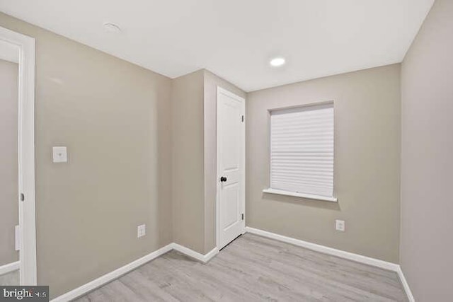 unfurnished room featuring wood finished floors, baseboards, and recessed lighting