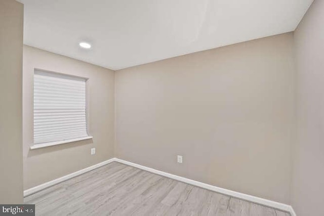 unfurnished room with baseboards, wood finished floors, and recessed lighting