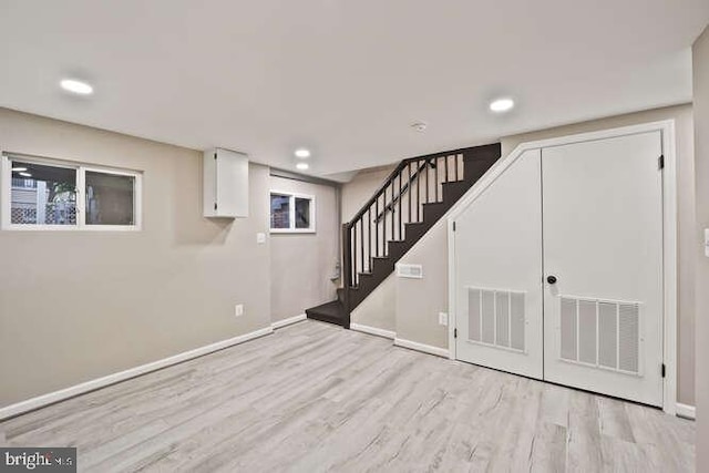 finished basement featuring wood finished floors, stairway, baseboards, and recessed lighting