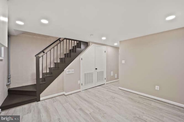 basement with wood finished floors, stairway, baseboards, and recessed lighting