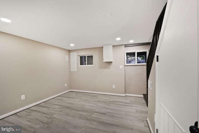 finished basement with baseboards, recessed lighting, and light wood finished floors