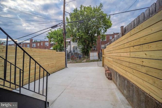 view of property exterior featuring fence and a patio