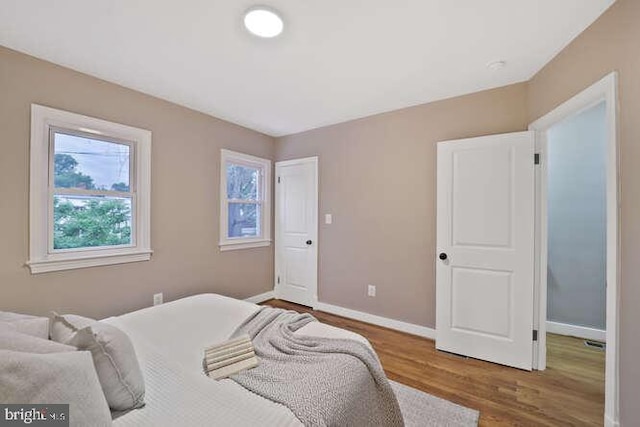 bedroom with wood finished floors and baseboards