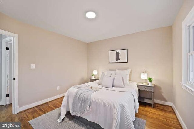 bedroom featuring baseboards and wood finished floors