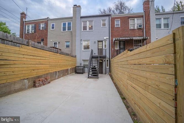 rear view of property with fence and central AC