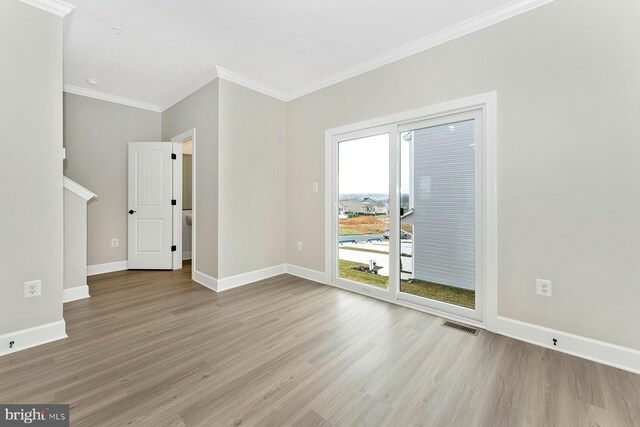 unfurnished living room with wood finished floors, ornamental molding, and baseboards