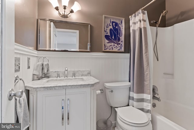 full bath with wainscoting, toilet, vanity, and shower / bathtub combination with curtain