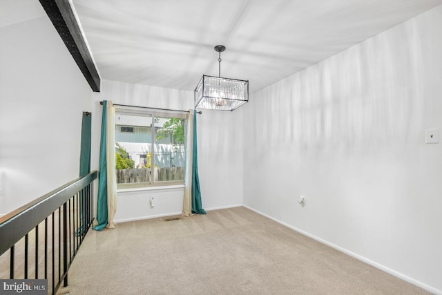 unfurnished room featuring a chandelier, carpet flooring, and baseboards