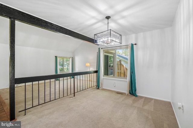 empty room with a chandelier, carpet flooring, baseboards, and vaulted ceiling