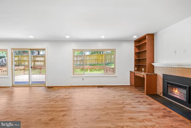 unfurnished living room featuring a fireplace, light wood-style floors, recessed lighting, and baseboards