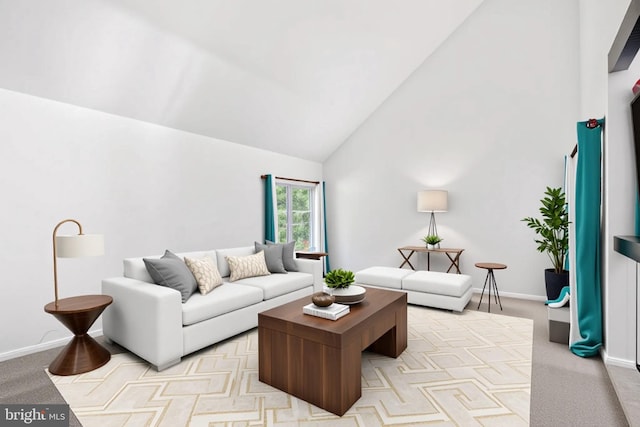 living area with high vaulted ceiling, light carpet, and baseboards