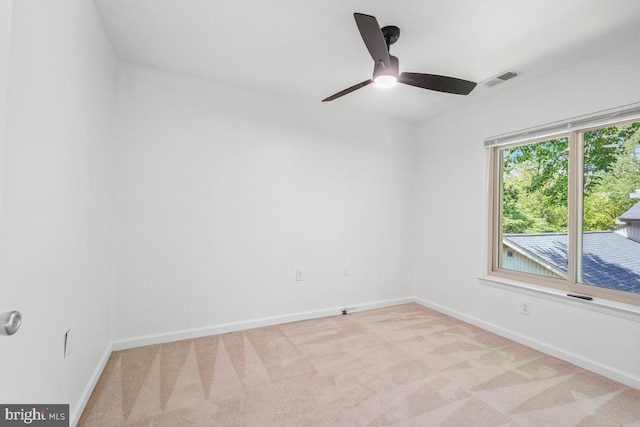 carpeted spare room with baseboards and a ceiling fan