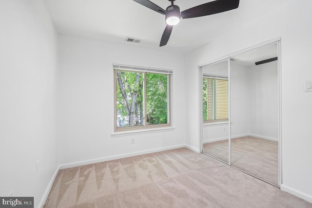 unfurnished bedroom featuring carpet flooring, a closet, baseboards, and ceiling fan