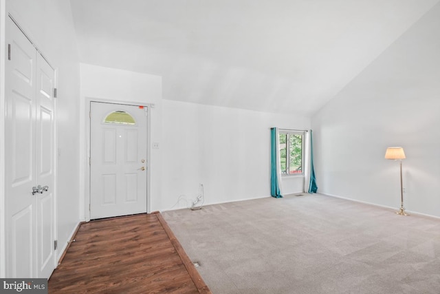 entrance foyer with lofted ceiling and carpet flooring