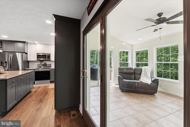 501 Macmillan Ct, Arnold, MD 21012 - kitchen with stainless steel appliances, light stone counters, open floor plan, a textured ceiling, and recessed lighting