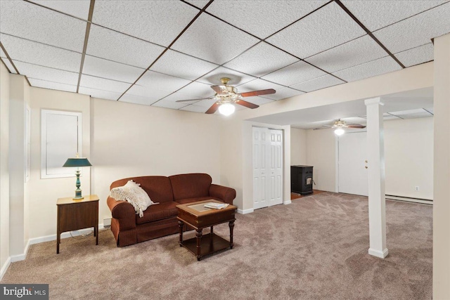 501 Macmillan Ct, Arnold, MD 21012 - carpeted living room featuring a wood stove, a paneled ceiling, baseboards, and a ceiling fan