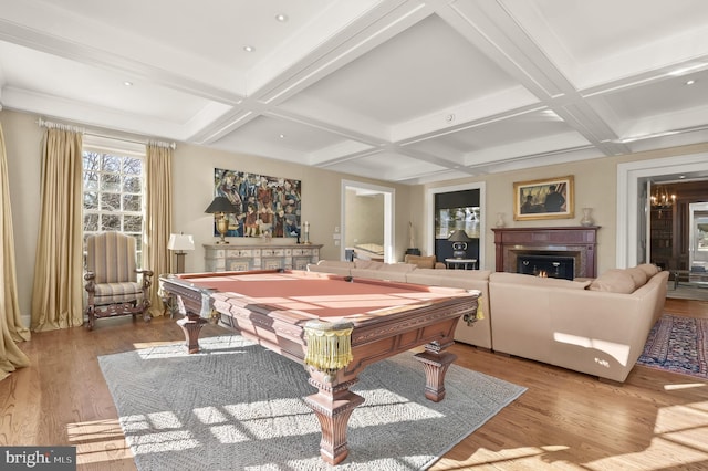 game room with coffered ceiling, wood finished floors, billiards, a warm lit fireplace, and beamed ceiling