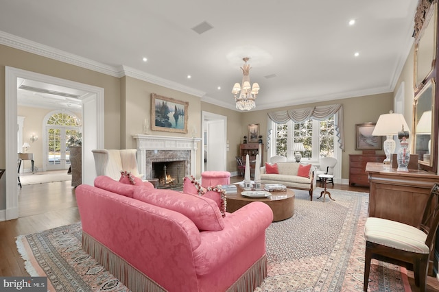 living room with a fireplace, recessed lighting, a chandelier, wood finished floors, and baseboards