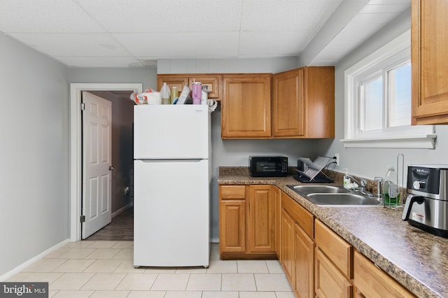 4508 Post Rd, Marcus Hook, PA 19061 - kitchen featuring freestanding refrigerator, a sink, a drop ceiling, light tile patterned floors, and baseboards