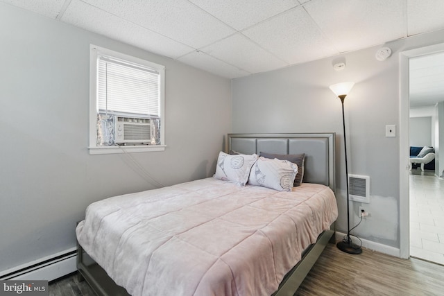 4508 Post Rd, Marcus Hook, PA 19061 - bedroom with a baseboard radiator, a drop ceiling, wood finished floors, cooling unit, and baseboards