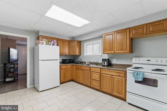 4508 Post Rd, Marcus Hook, PA 19061 - kitchen featuring white appliances, a sink, brown cabinetry, a paneled ceiling, and dark countertops