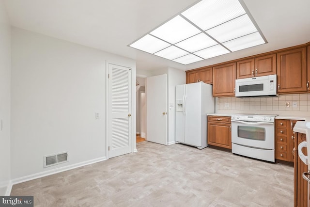 10620 Seneca Ridge Dr, Gaithersburg, MD 20886 - kitchen featuring white appliances, brown cabinets, light countertops, and light flooring