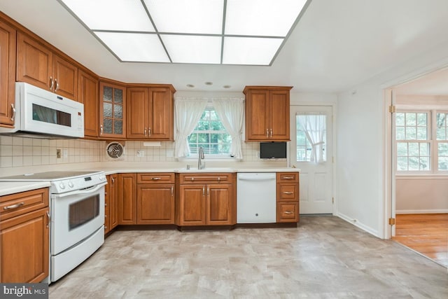 10620 Seneca Ridge Dr, Gaithersburg, MD 20886 - kitchen featuring white appliances, brown cabinetry, a sink, and light countertops