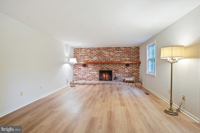 10620 Seneca Ridge Dr, Gaithersburg, MD 20886 - unfurnished living room featuring light wood-style floors, baseboards, and a brick fireplace