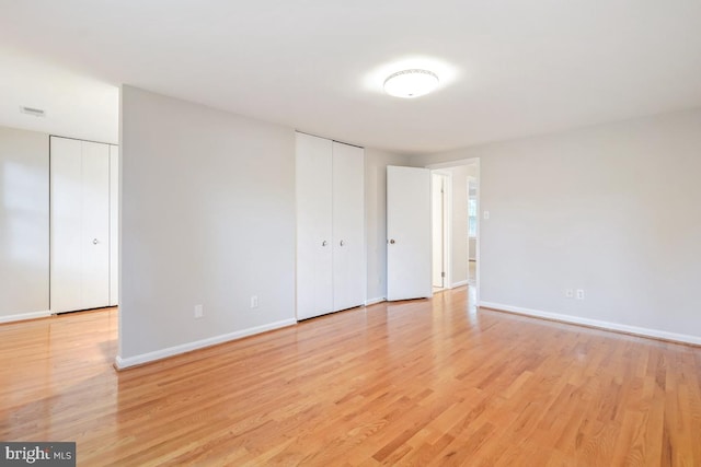 10620 Seneca Ridge Dr, Gaithersburg, MD 20886 - unfurnished bedroom with light wood-style floors, baseboards, and multiple closets