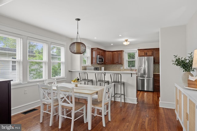 dining space featuring dark wood finished floors, baseboards, and recessed lighting