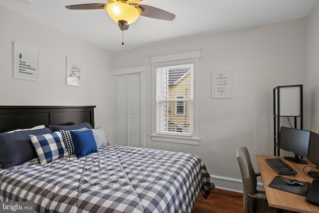 bedroom featuring wood finished floors, baseboards, ceiling fan, and an office area