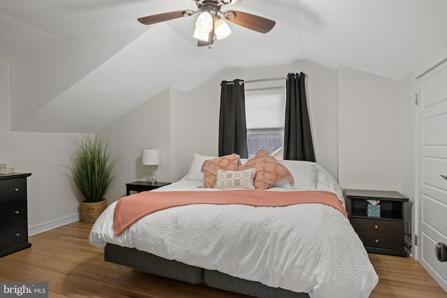 bedroom featuring vaulted ceiling, wood finished floors, a ceiling fan, and baseboards