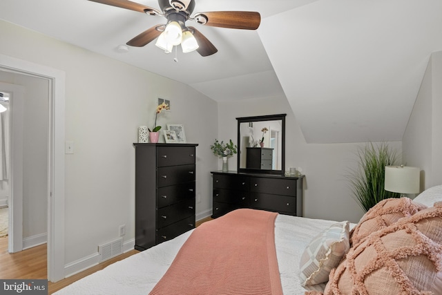 bedroom featuring lofted ceiling, light wood-style floors, baseboards, and ceiling fan
