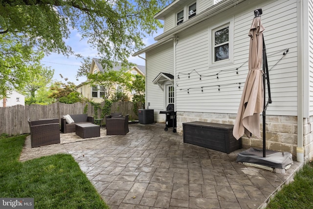 view of patio / terrace featuring fence, an outdoor living space, and central air condition unit